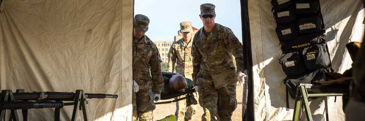 Army service members carry injured service member in training